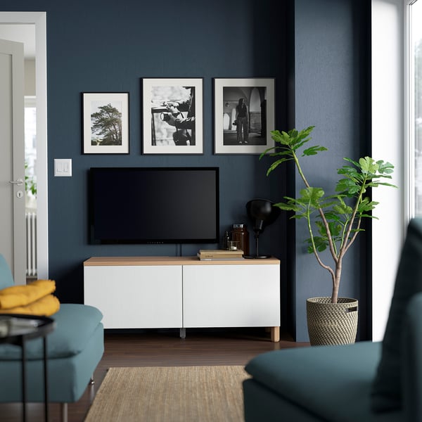 Modern living room with BESTÅ tv bench, art, turquoise sofa, and large plant.
