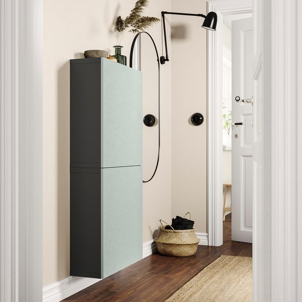 Modern entryway with teal & black BESTÅ cabinet, wall lamp, wicker basket.