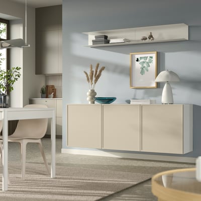 Ikea BESTÅ cream-colored wall-mounted cabinet. Modern design with three doors, offering airy storage solution.