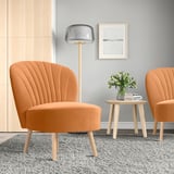 Modern minimalist room with orange BILLHAMN chairs, wooden side table, and tall lamp.