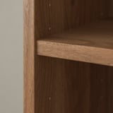 Close-up of a wooden bookshelf edge, showcasing fine grain texture and smooth finish.