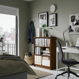 Modern bedroom with BILLY bookcase, desk, chair, plants & city view.
