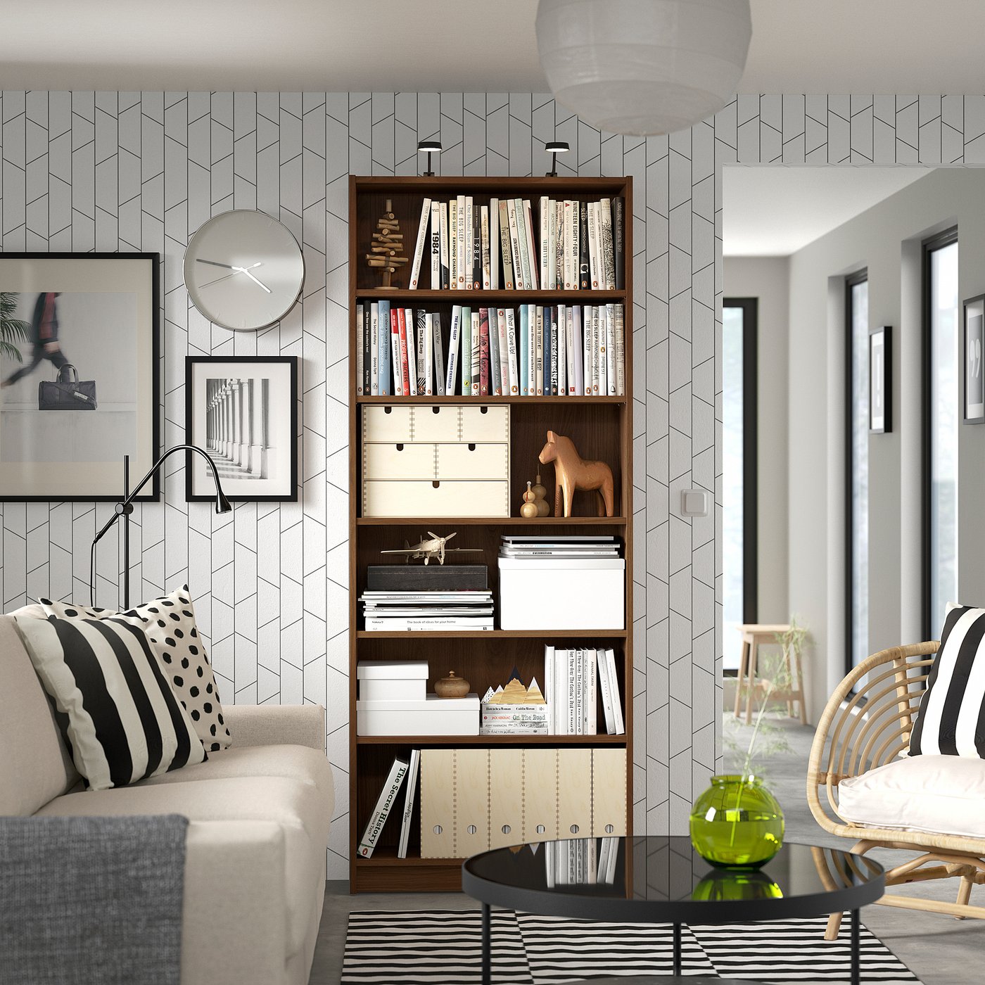 Modern living room with BILLY bookcase, beige sofa, black coffee table, and geometric-patterned wall.