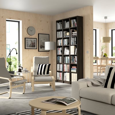 Modern living room with BILLY bookcase, books, light wood walls, and large window.