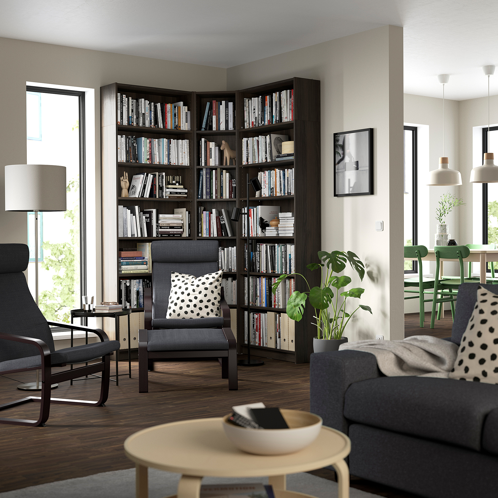 Cozy living room with tall BILLY bookcase between window and gray couch, filled with books and decor, illuminated by natural light.