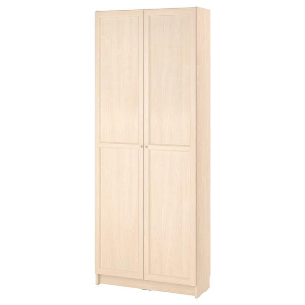 A BILLY bookcase in light beige, featuring two doors and adjustable shelves, made from particleboard and paper foil.
