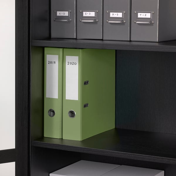 Shelf with green binders labeled 2019, 2020, and alphabetized boxes.
