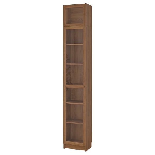 A tall, wooden BILLY bookcase with five shelves and glass doors at the top. Its an elegant storage solution with a natural wood finish.