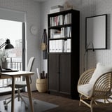 Home office with BILLY bookcase: taller than chair, dark wood, geometric wallpaper, white accessories, natural light.