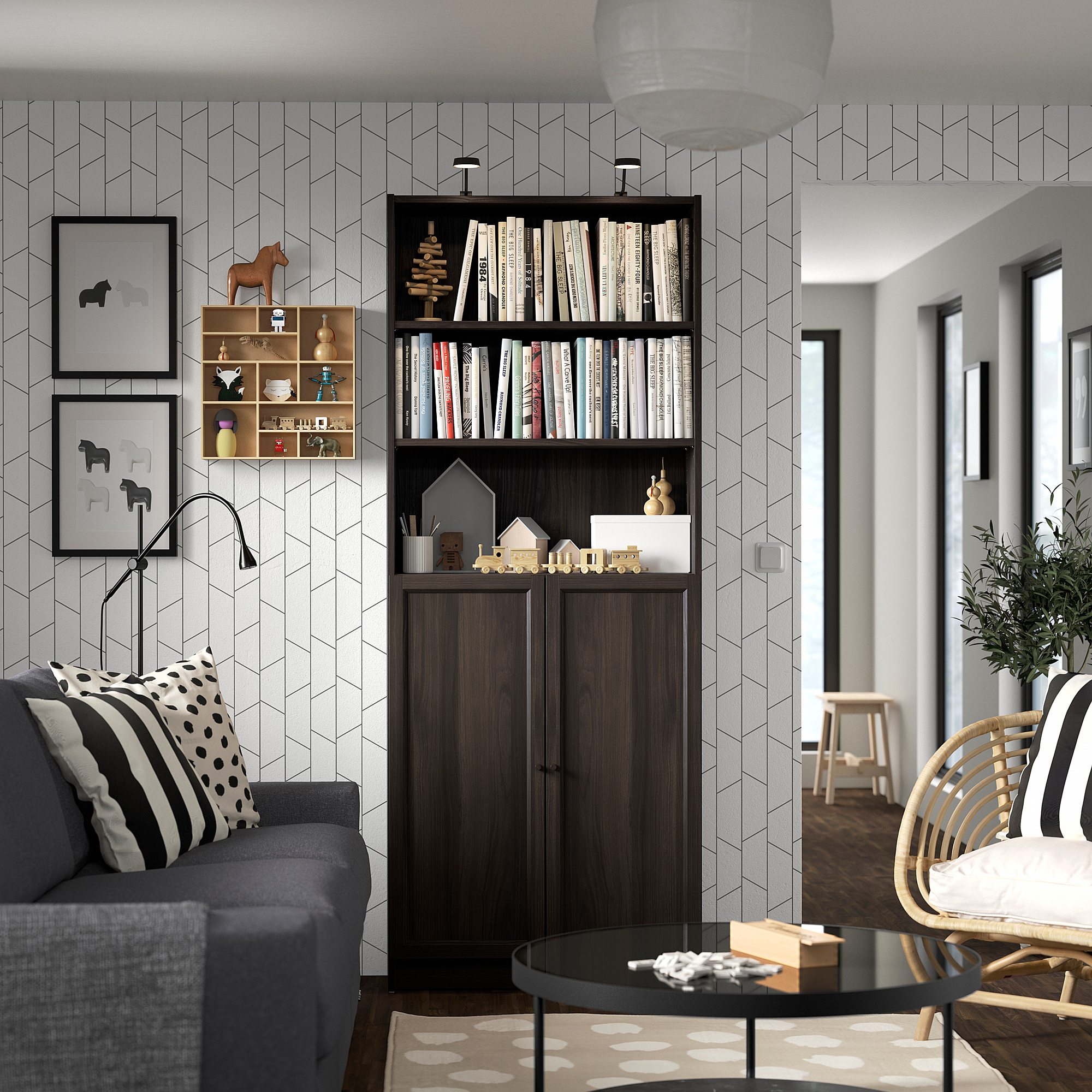 Modern living room with BILLY bookcase, grey couch, round table, and pendant light.