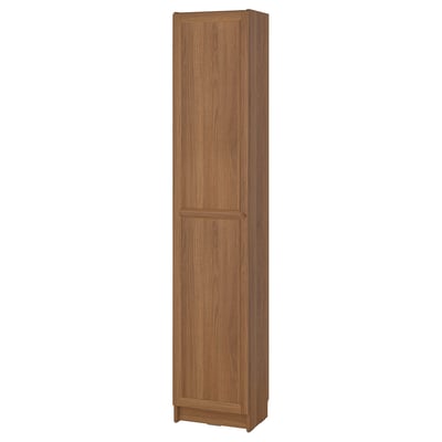 A BILLY tall bookcase in oak colour, made of particleboard and fiberboard, standing upright with two doors.