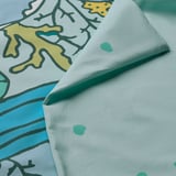 Vibrant blue duvet fold, showing crisp fabric, colorful ocean print.