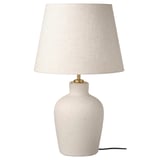 White ceramic table lamp with brass lamp holder and beige textured shade.