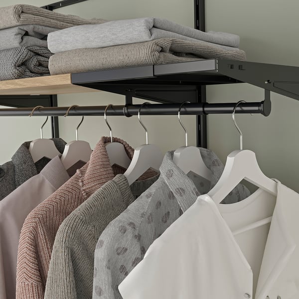 Closet with adjustable shelves and hangers, displaying neatly organized clothes.