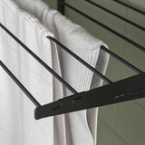 Image shows BOAXEL drying rack holding white towels, efficiently organizing laundry.