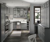 Modern grey kitchen with beveled panel cabinets, stainless steel appliances, white sink, and wooden floor.