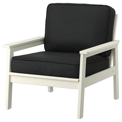 Black and white outdoor armchair with dark cushions, featuring a modern design and made of acacia wood and plastic.