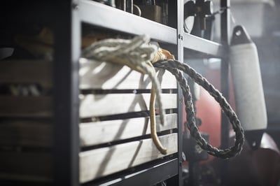 Close-up of BROR, gray shelf, metal, industrial design, with ropes.