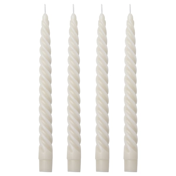 Four white spiral candles in a row. Made of paraffin and cotton. Tall, twisted design.