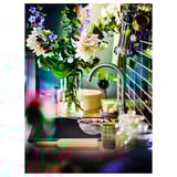 A modern kitchen sink with a delsjon mixer tap in a pewter finish, featuring a bouquet of flowers.