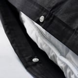 Close-up of duvet covers press-stud closure, showcasing its functional design.