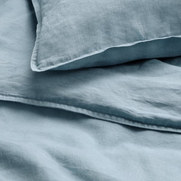 Crisp, sky-blue linen duvet set, showcasing a soft, textured finish and neat fold, emphasizing its high-quality, casual elegance.