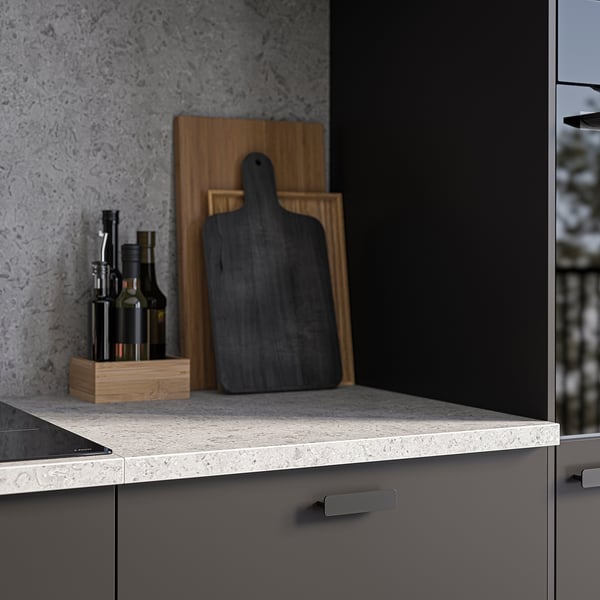 Modern kitchen counter with grey EKBACKEN stone effect laminate, wooden cutting boards, and oil bottles.