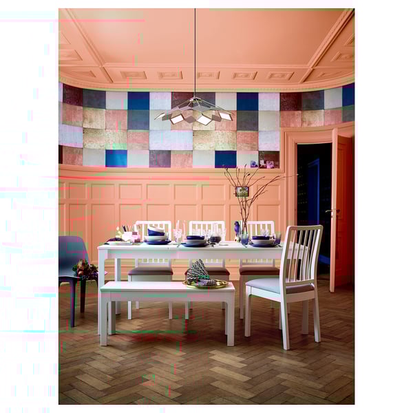 Bright dining room with peach walls, colorful tiled backsplash, white EKEDALEN furniture including a bench, table, and chairs.
