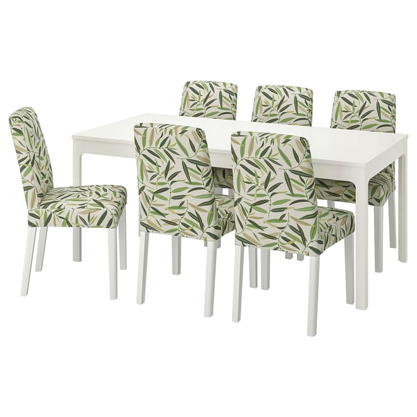 White dining table with 6 chairs, white with green leaf-patterned covers.