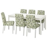 White dining table with 6 chairs, white with green leaf-patterned covers.
