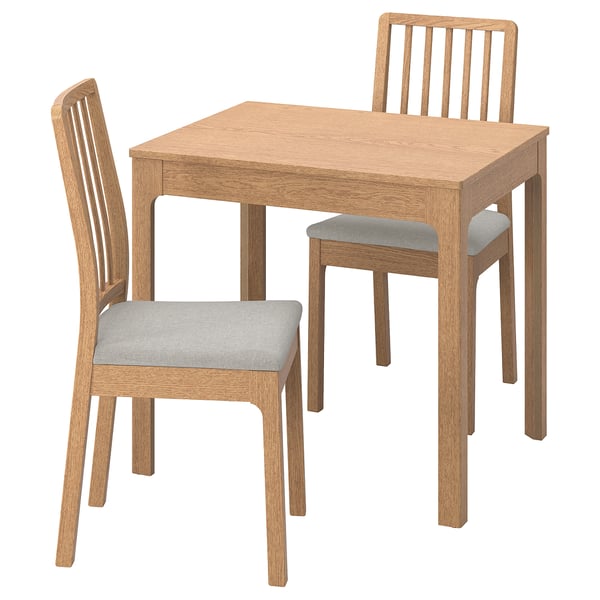 Modern wooden dining set with oak table and two upholstered chairs.