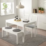 White EKEDALEN dining set with extendable table, gray chairs, and round-cushioned bench in modern kitchen.