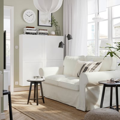 Modern living room with white EKTORP sofa, side tables, and bookshelf, filled with natural light.