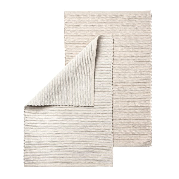 Handwoven beige cotton rug, unique design, rectangular shape, soft texture.