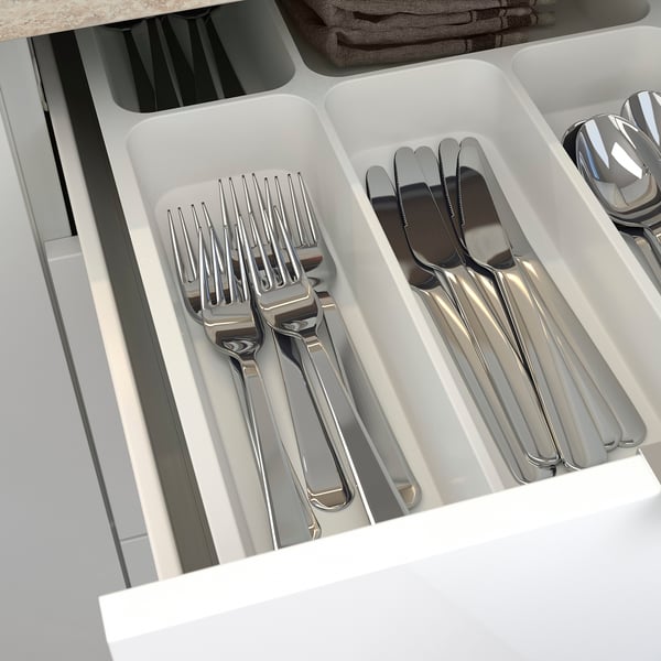 A silverware organizer with forks, knives, and spoons in compartments, making kitchen utensils easy to access and store.