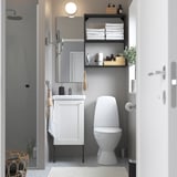 Modern bathroom with white ENHET vanity, toilet, mirror, and open shelf storage. Gray tiled floor.