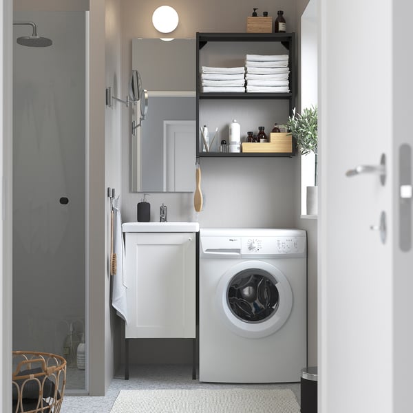 Small, white laundry room with ENHET cabinet, shelves, washer, and mirror. Clean, modern design with minimalist decor.