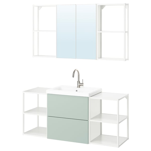 Modern bathroom setup with mint cabinet, white sink, chrome tap, and mirror unit.