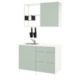 Modern kitchen setup: light green cabinets with sleek silver sink, stainless steel mixer, black containers, white background.