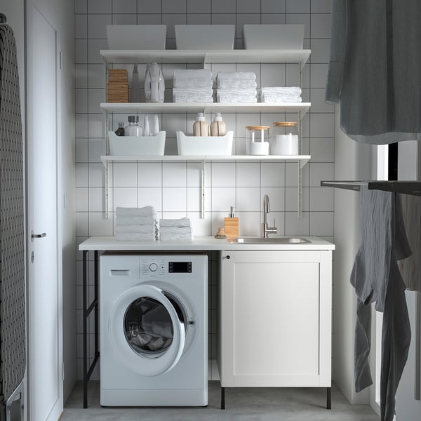 Modern laundry room with white ENHET unit. Counter, sink, washing machine, and storage shelves.