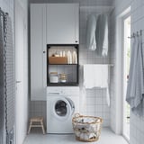 Modern laundry room with white ENHET storage unit, washing machine, drying rack, and wicker basket.