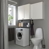 ENHET laundry setup with cabinets, appliances, and decor.