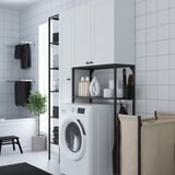 White ENHET laundry unit in bathroom corner with washing machine, cabinets, shelves, and towels.