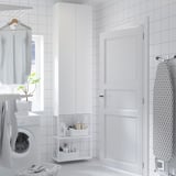 Minimalist laundry room with white ENHET storage, washing machine, and ironing board.