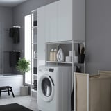 Modern grey laundry area with ENHET white cabinet, washing machine, shelves, and hanging towels. Space-efficient design.