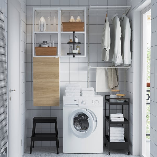 Laundry setup: ENHET washing machine, open shelves, wall cabinet, swivel shelf, towels, black trolley.