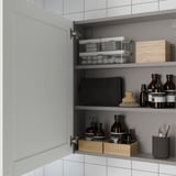 Open bathroom cabinet with shelves showing organized toiletries.