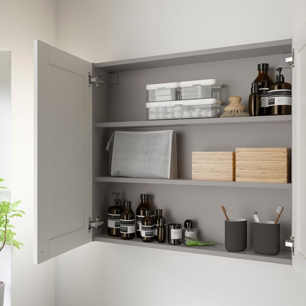 Open wall cabinet with bottles, jars, and containers neatly organized on shelves. Ample storage space for toiletries and bathroom essentials.