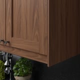 Wooden kitchen cabinets with dark countertop, featuring potted plant and citrus juicer.
