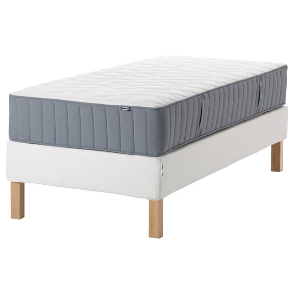 IKEA espevär twin mattress on white bed frame. Rectangular, grey-blue top, wooden legs.